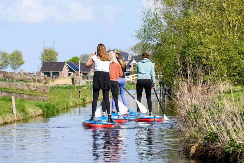 personen aan het suppen op het water